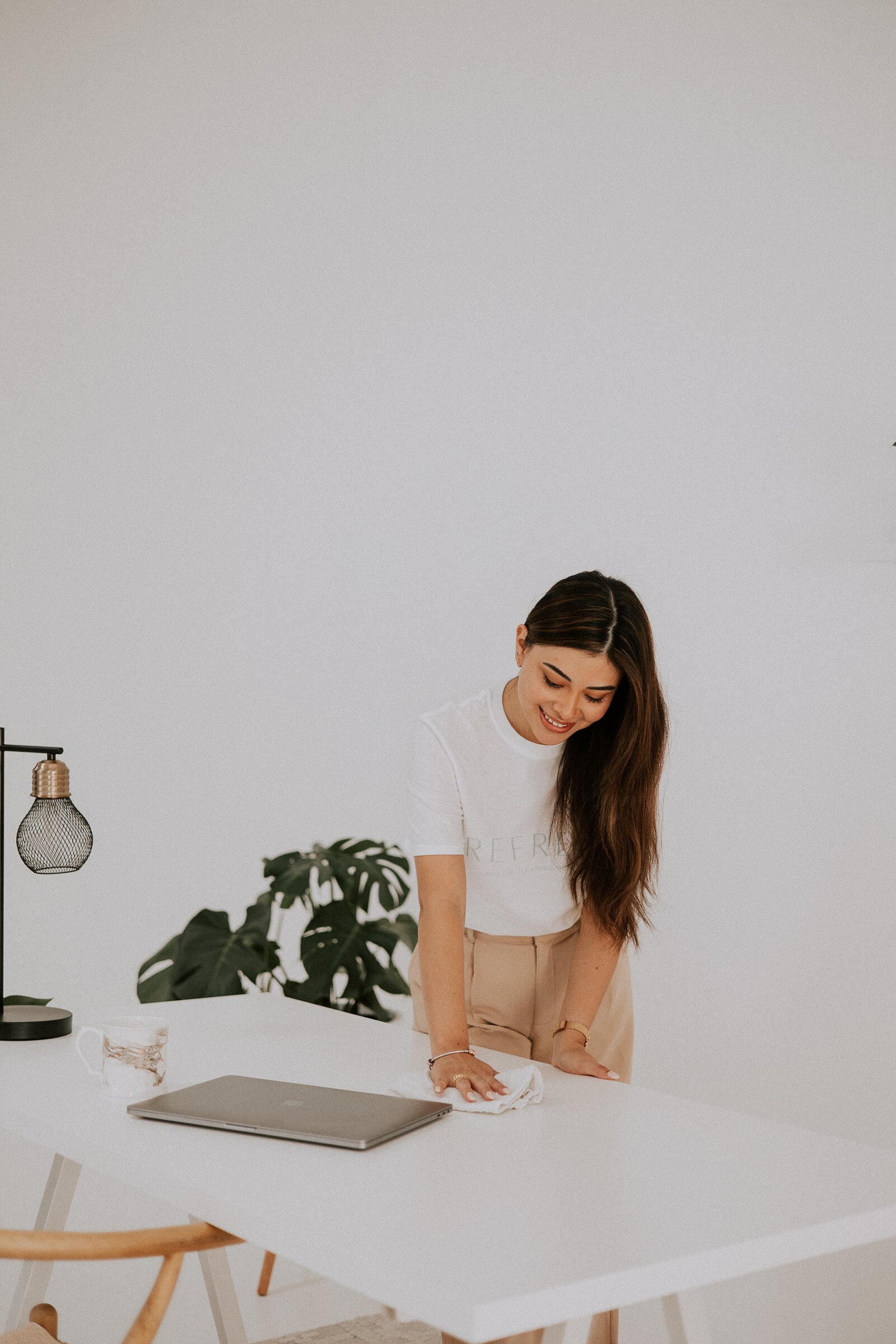 Refresh Spaces team member wiping a desk in a bright home office